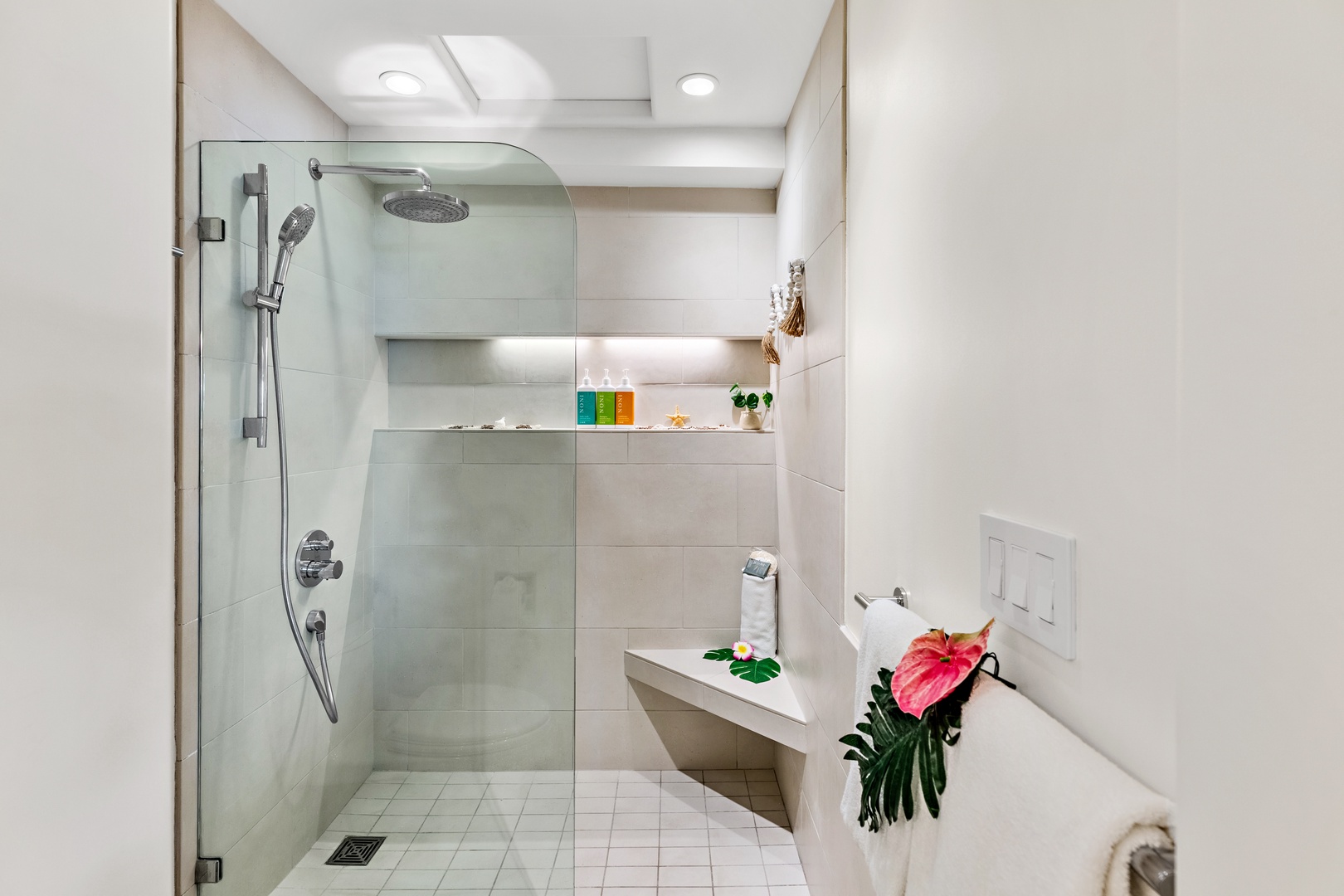 Step into your private spa-like bathroom, where a sleek walk-in shower and built-in seating invite you to unwind. Bright lighting and modern touches create a soothing retreat for your morning routine or evening relaxation.