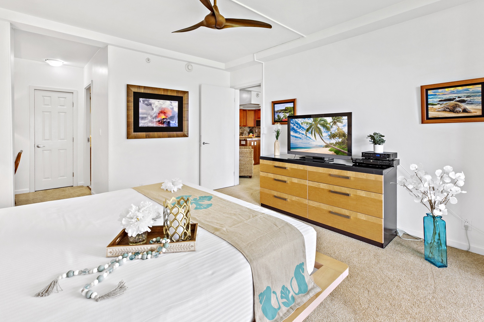 Relax in your bright, airy bedroom featuring tropical décor, modern entertainment setup, and thoughtful touches that create your perfect coastal retreat.