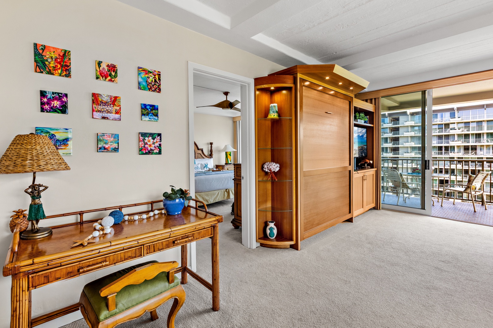 Step into your spacious living area featuring vibrant tropical artwork, warm wood furnishings, and stunning city views from your private balcony.