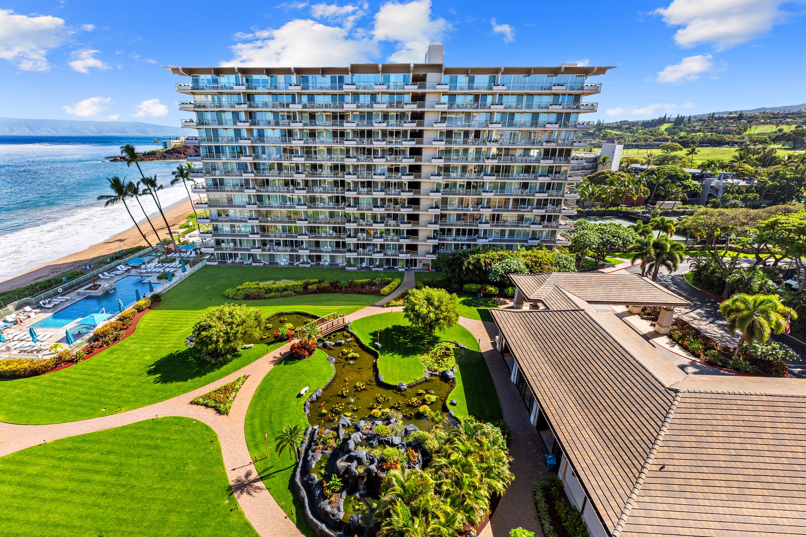 Beachfront property featuring pristine grounds, sparkling pool, and direct ocean access amid lush tropical landscaping and scenic coastal surroundings.