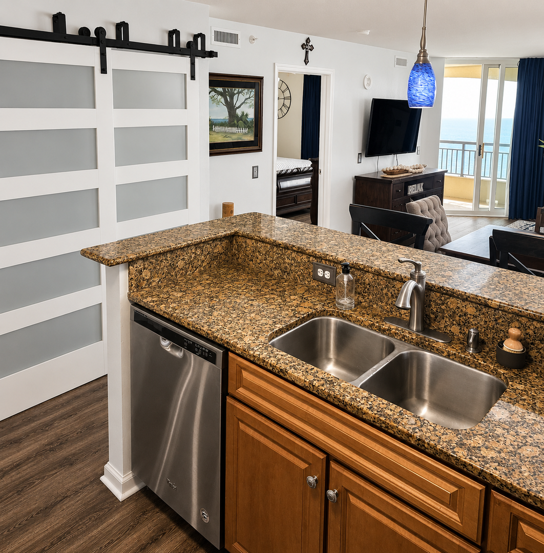 Prepare your favorite meals in this fully-equipped kitchen with granite countertops, stainless steel appliances, and stunning ocean views through the living area.