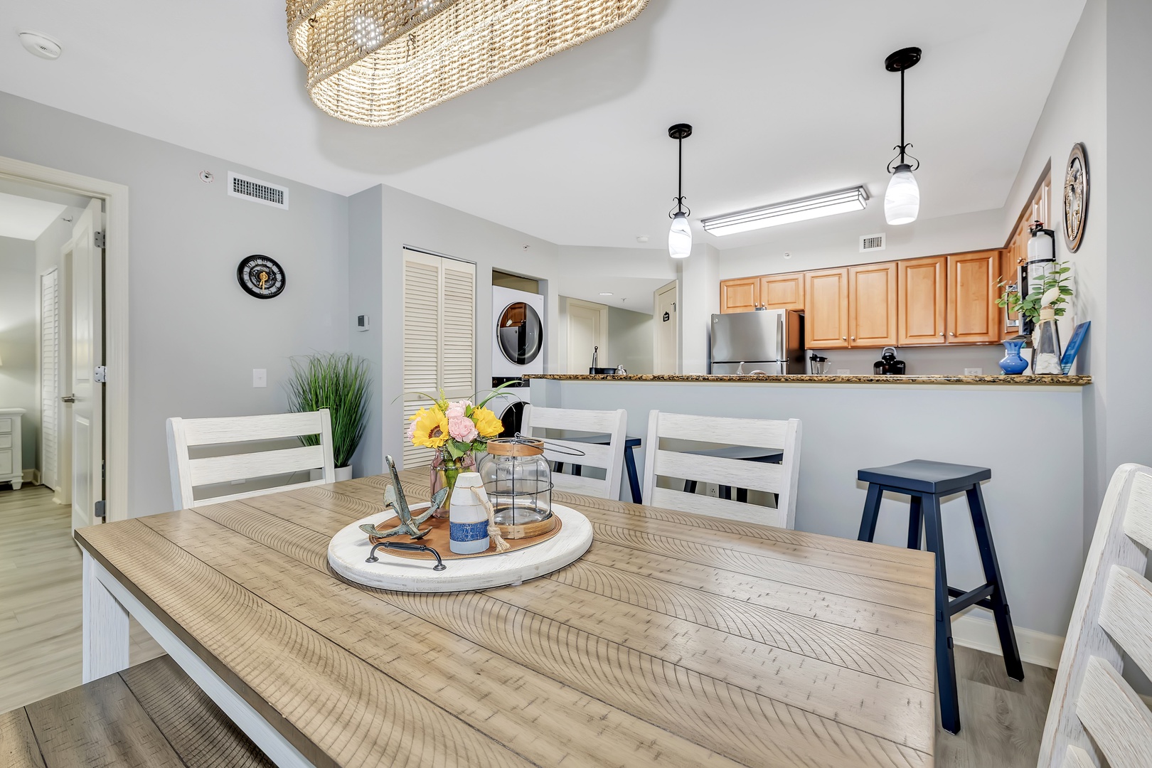 Gather around your spacious dining table, where bright natural light and coastal-inspired decor create the perfect setting for morning coffee or shared meals with loved ones.