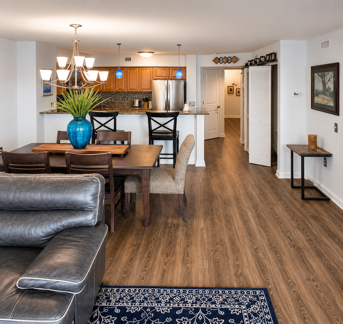 Settle into your open-concept living space, where warm wood floors meet modern comfort. The full kitchen and dining area flow seamlessly into a cozy lounge—perfect for unwinding after exploring nearby attractions.