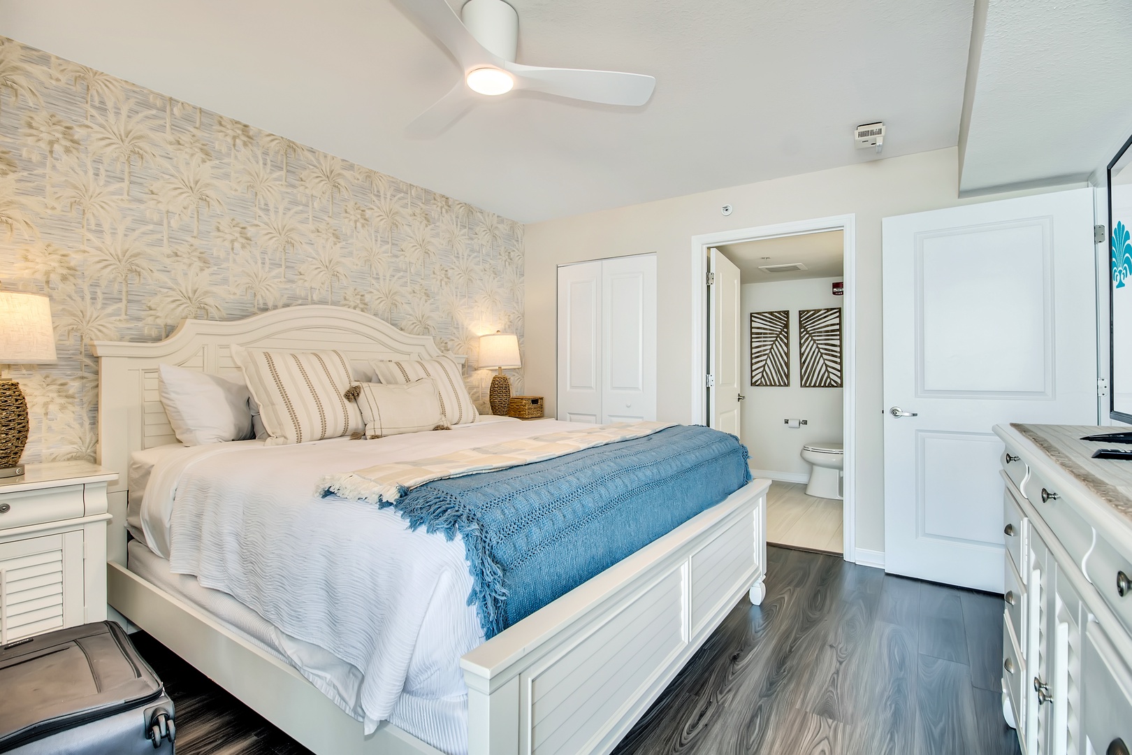 Relax in your tropical-inspired bedroom with premium linens, gentle ceiling fan, and convenient kitchenette. Your stylish white furnishings create coastal comfort.