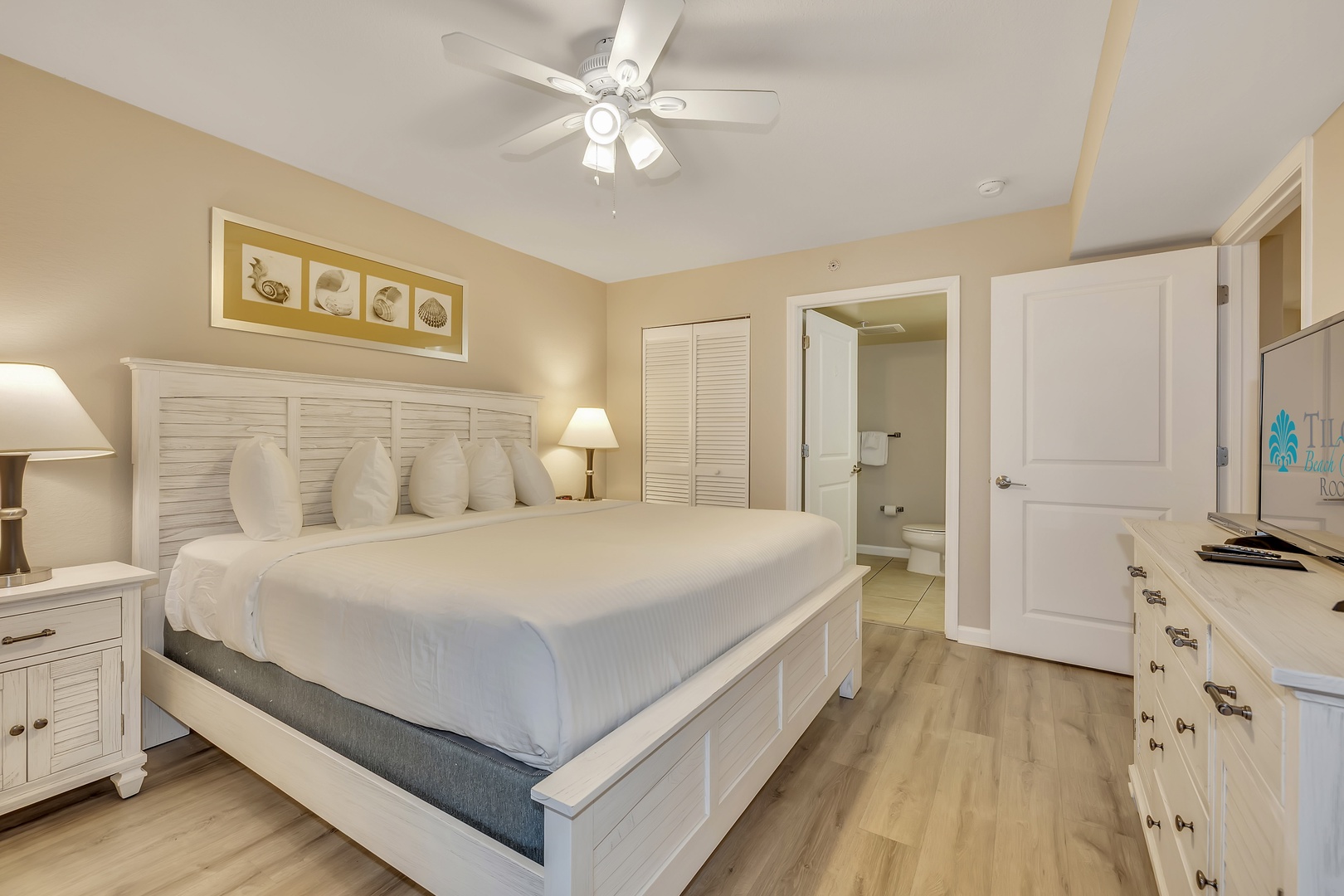 Unwind in your serene coastal bedroom with crisp linens, soft lighting, and a soothing palette. A ceiling fan keeps the air fresh while you rest, and your private bathroom is just steps away.