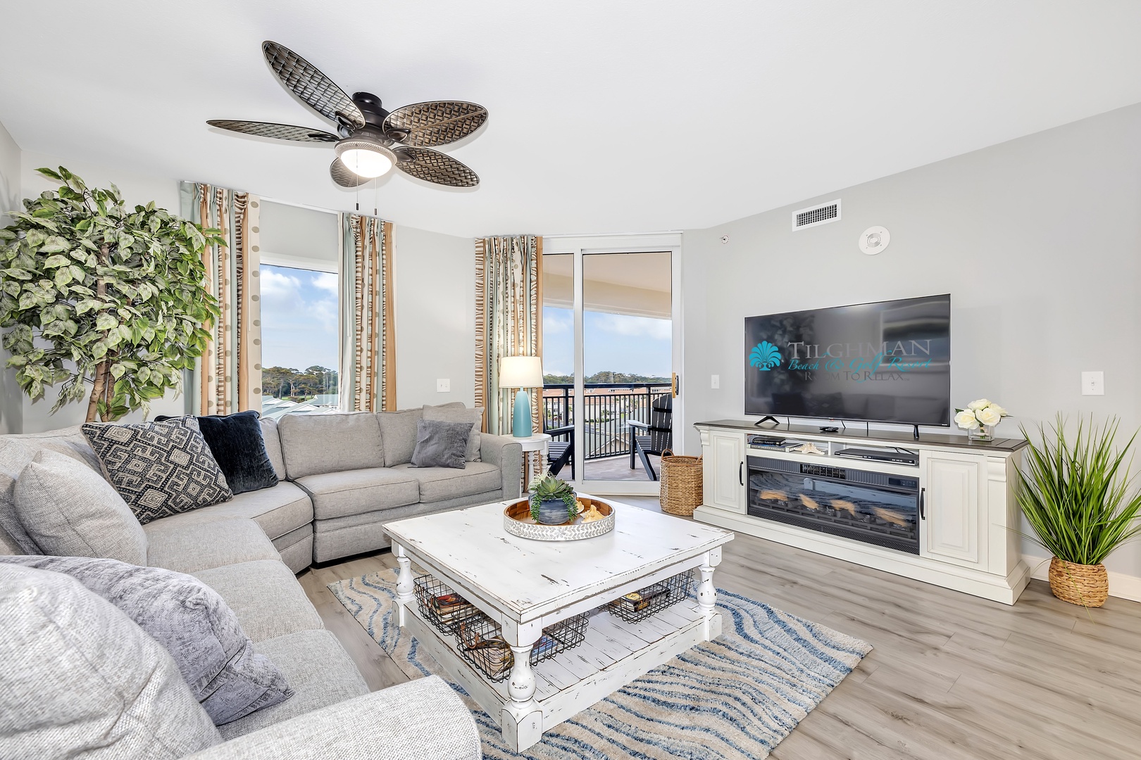 Unwind on plush sectional seating while enjoying gentle breezes from your tropical-style ceiling fan. Through the balcony doors, water views await to enhance your coastal retreat.