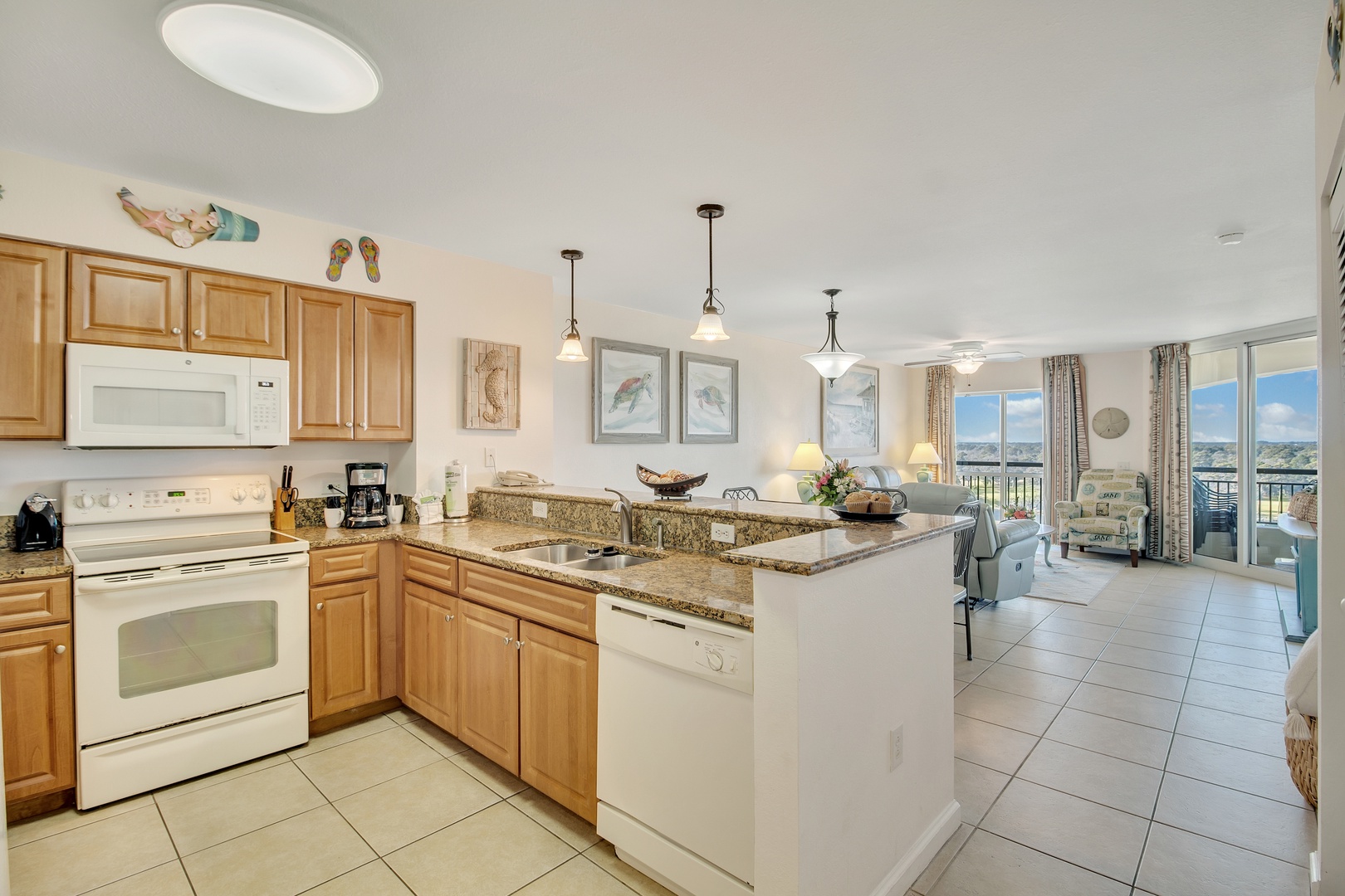 Your fully equipped kitchen flows seamlessly into the living space, where granite countertops and ocean views create the perfect backdrop for meal prep.