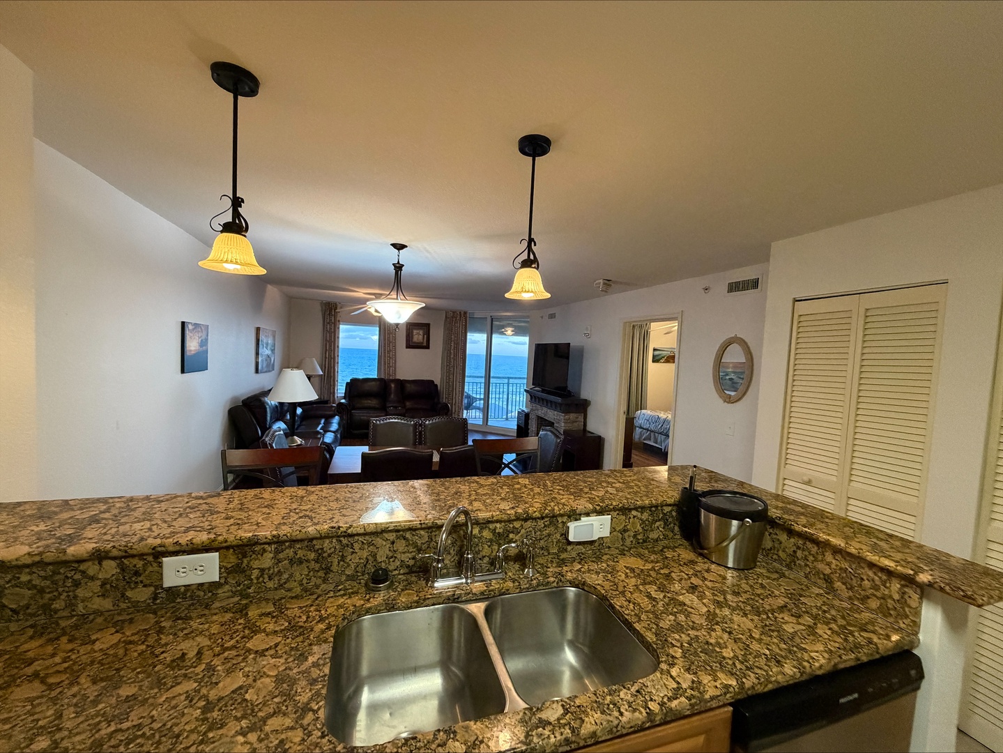 Your open-plan kitchen flows seamlessly into a comfortable living area with expansive ocean views through the balcony doors—perfect for easy entertaining and relaxing.