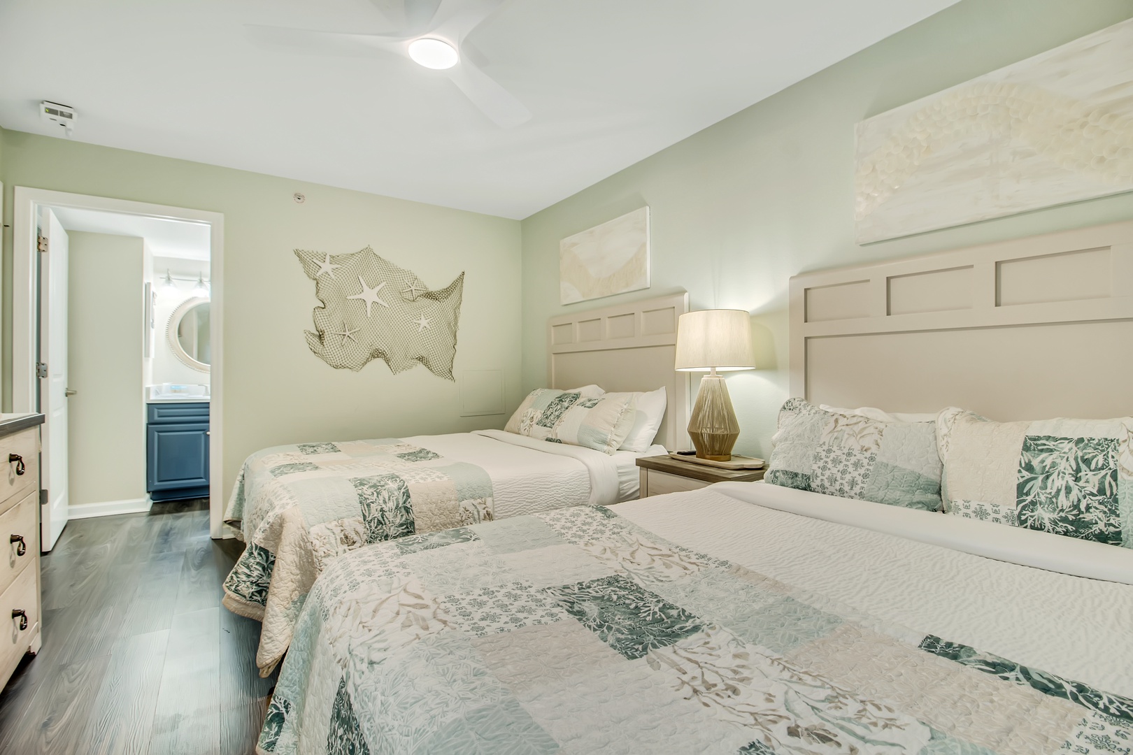 Relax in your tranquil twin bedroom featuring coastal-inspired décor, soft sage walls, and quality linens for peaceful nights.