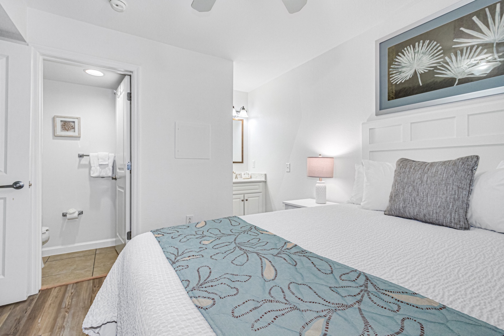 Rest peacefully in this serene bedroom with crisp white linens and coastal-inspired artwork creating your perfect retreat.