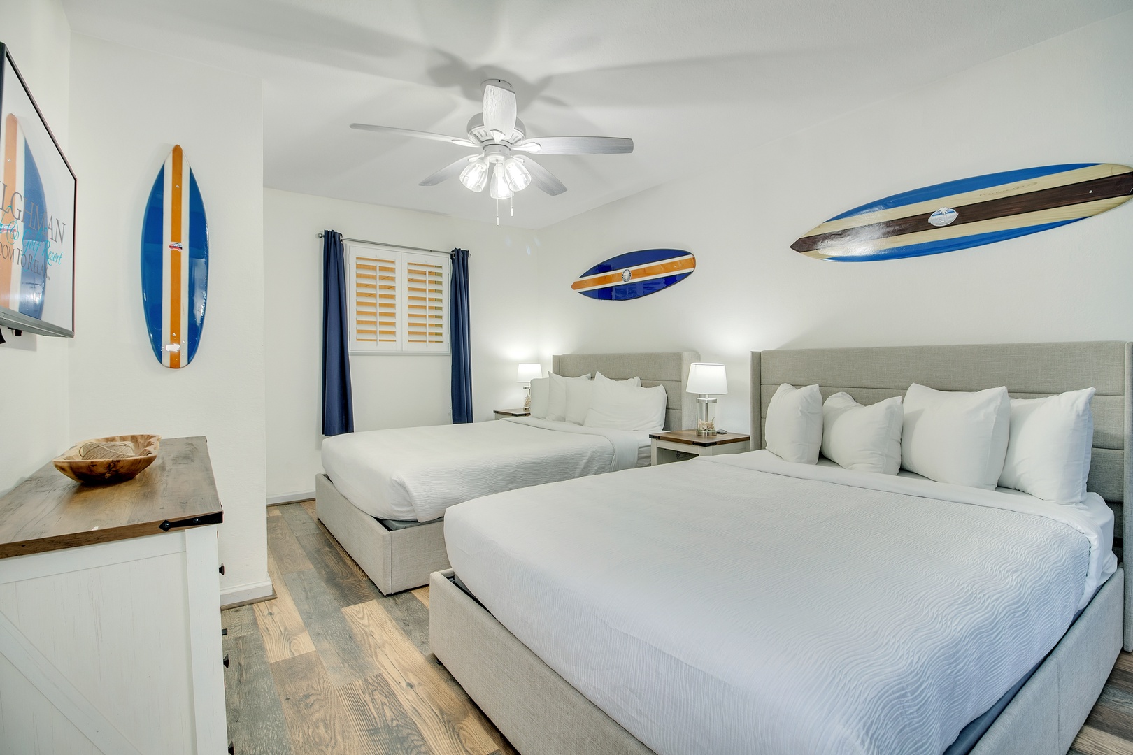 Sleep comfortably in your surf-themed bedroom with two plush beds, coastal decor, and gentle ceiling fan breezes.