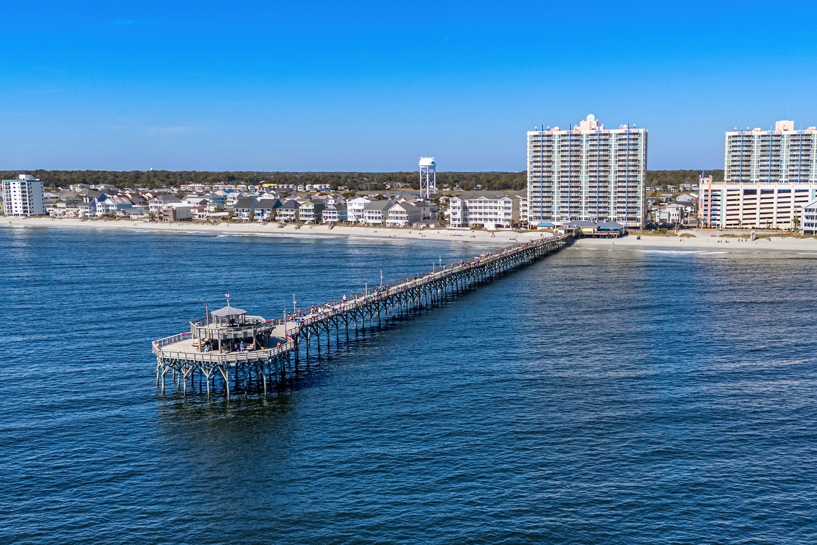 Aerial view showcasing the coastal area with beach, pier, and surrounding neighborhood—part of the property's scenic location near the waterfront and local attractions.