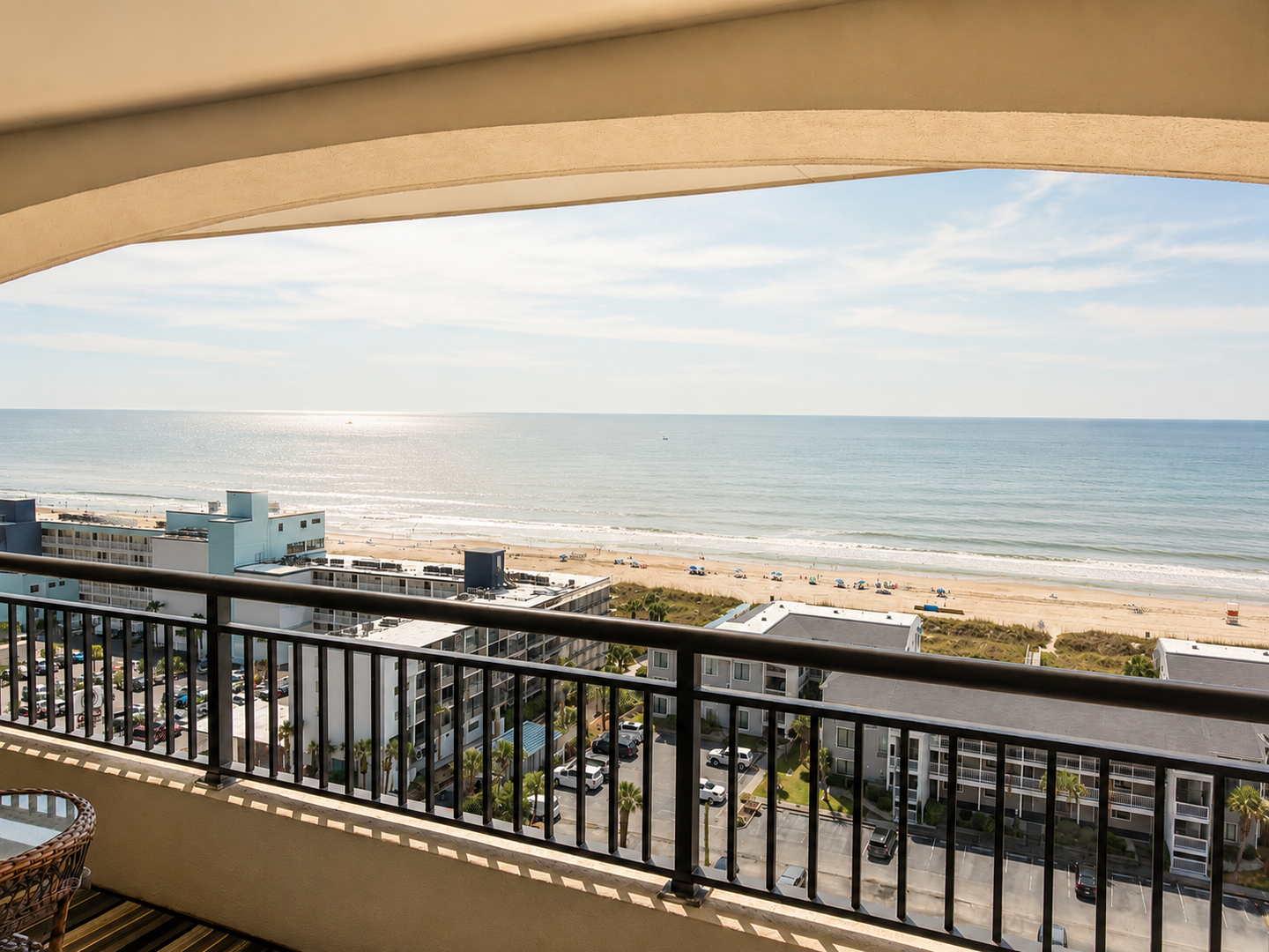 The property offers sweeping ocean views overlooking a sandy beach and coastal buildings, providing a scenic coastal setting for guests.