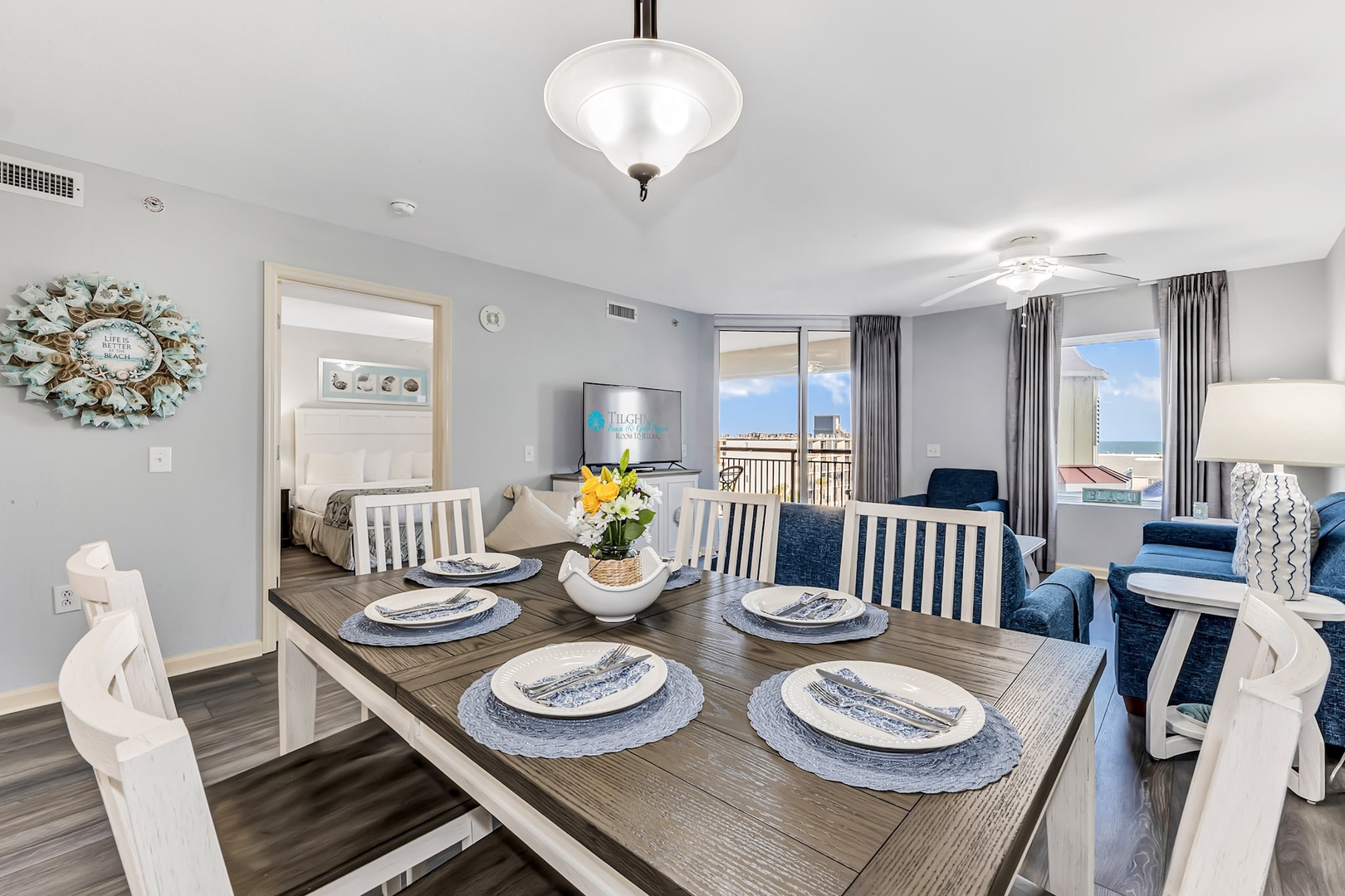 Gather for meals in this bright dining space with seating for five, opening to a living area and balcony with coastal views beyond.