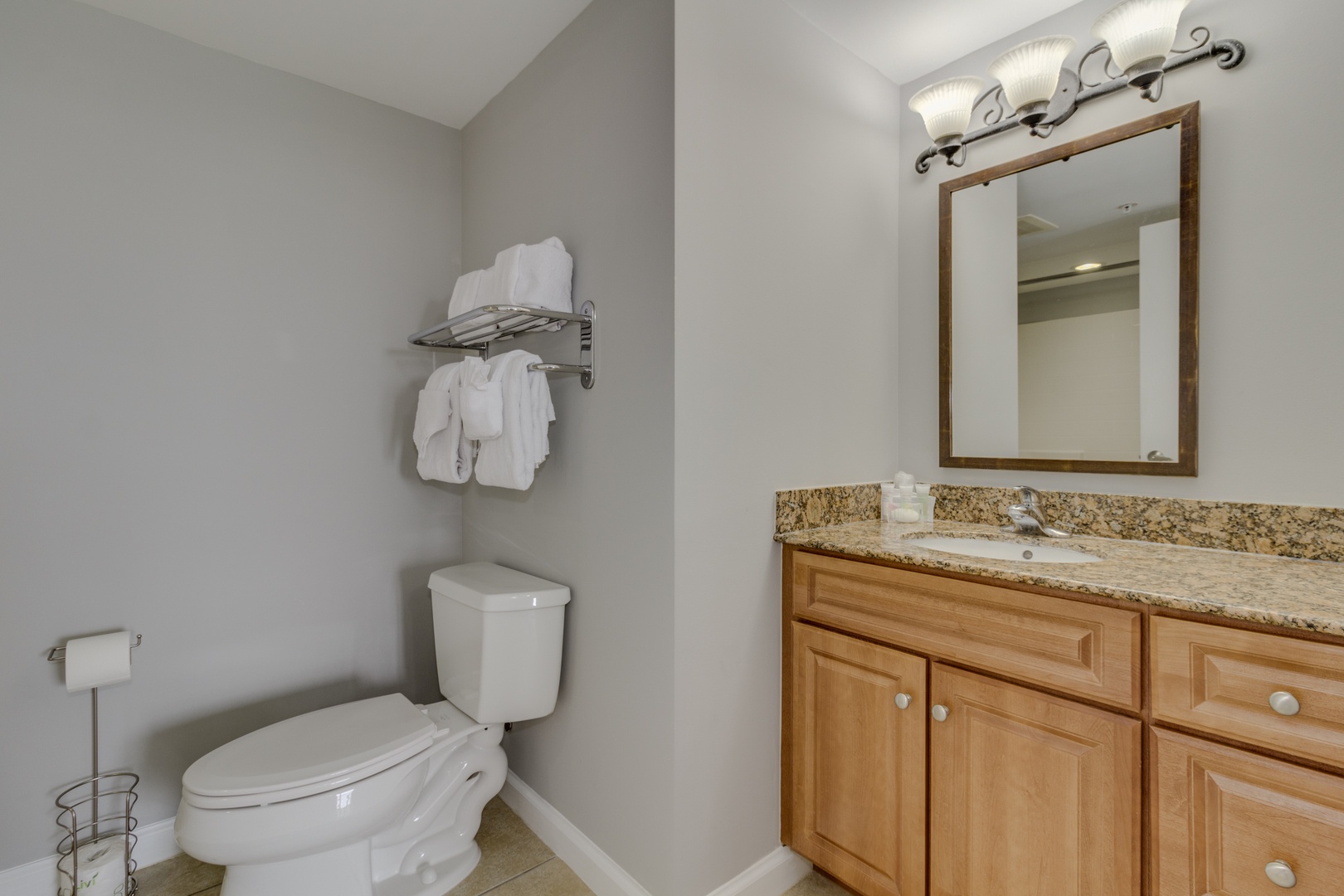 Refresh in your private bathroom with granite countertops, warm wood cabinetry, and fluffy towels waiting for you.