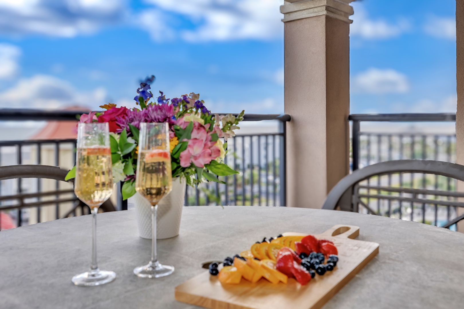 Sip chilled champagne and enjoy fresh fruit and cheese on your private balcony, overlooking charming rooftops and open skies—perfect for a relaxing morning or romantic evening.