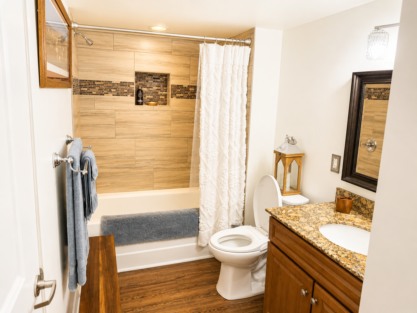 Refresh in your own private bathroom, featuring a granite vanity, elegant wood-look tile, and a full tub-shower combo for your comfort.