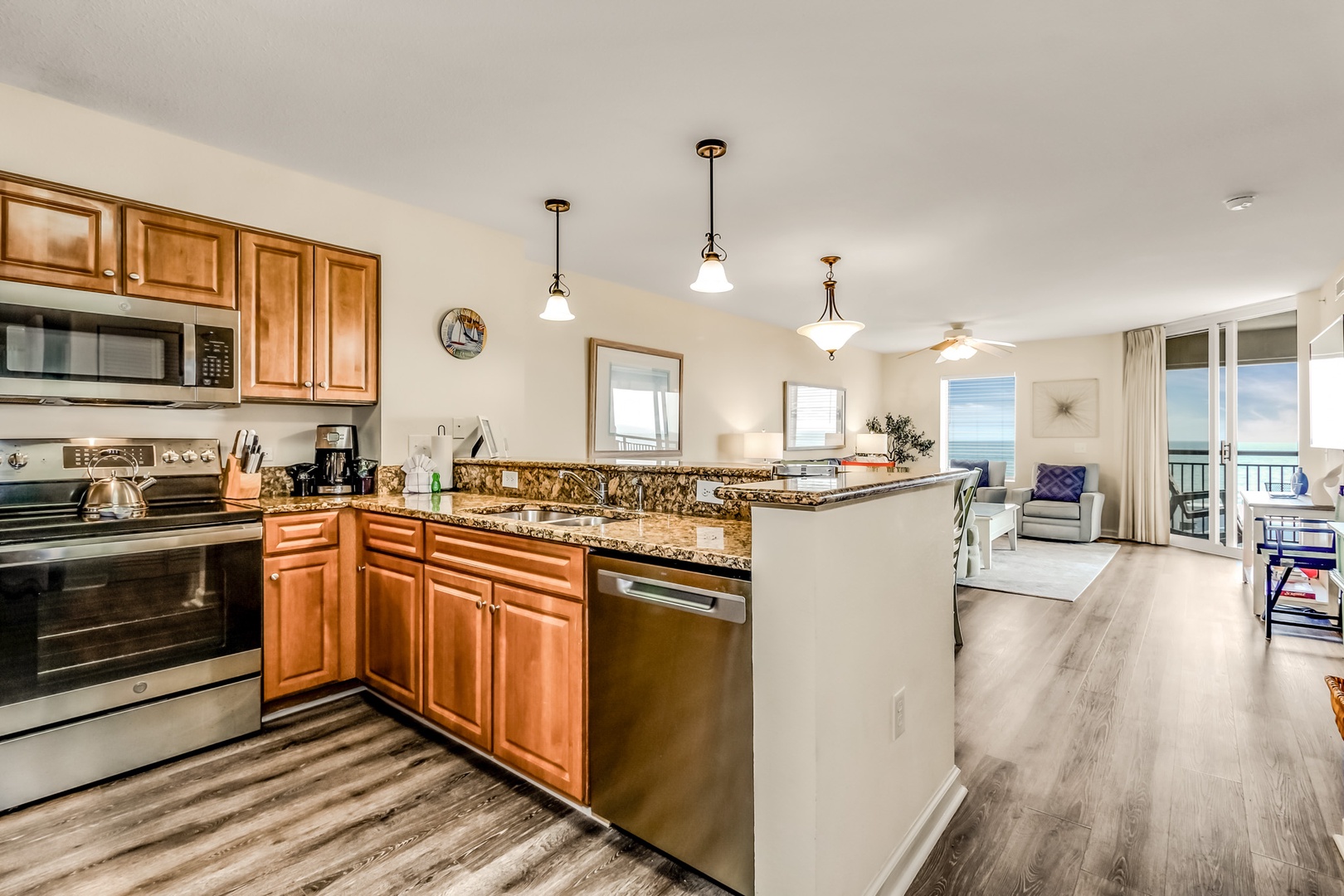 Your fully equipped kitchen flows seamlessly into the living area, perfect for preparing meals while enjoying ocean views through the balcony doors.