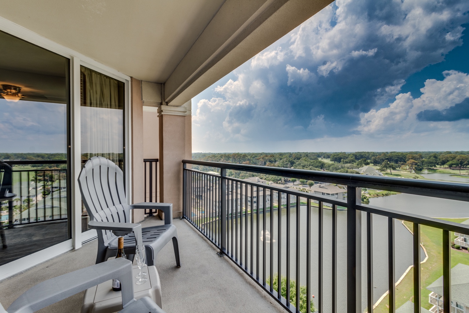 Step onto your private balcony and settle into comfortable seating with sweeping views of lush greenery below.