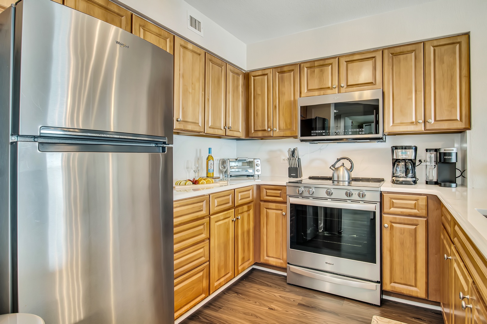 Your fully equipped kitchen awaits with stainless steel appliances and warm wood cabinets, perfect for preparing home-cooked meals during your stay.