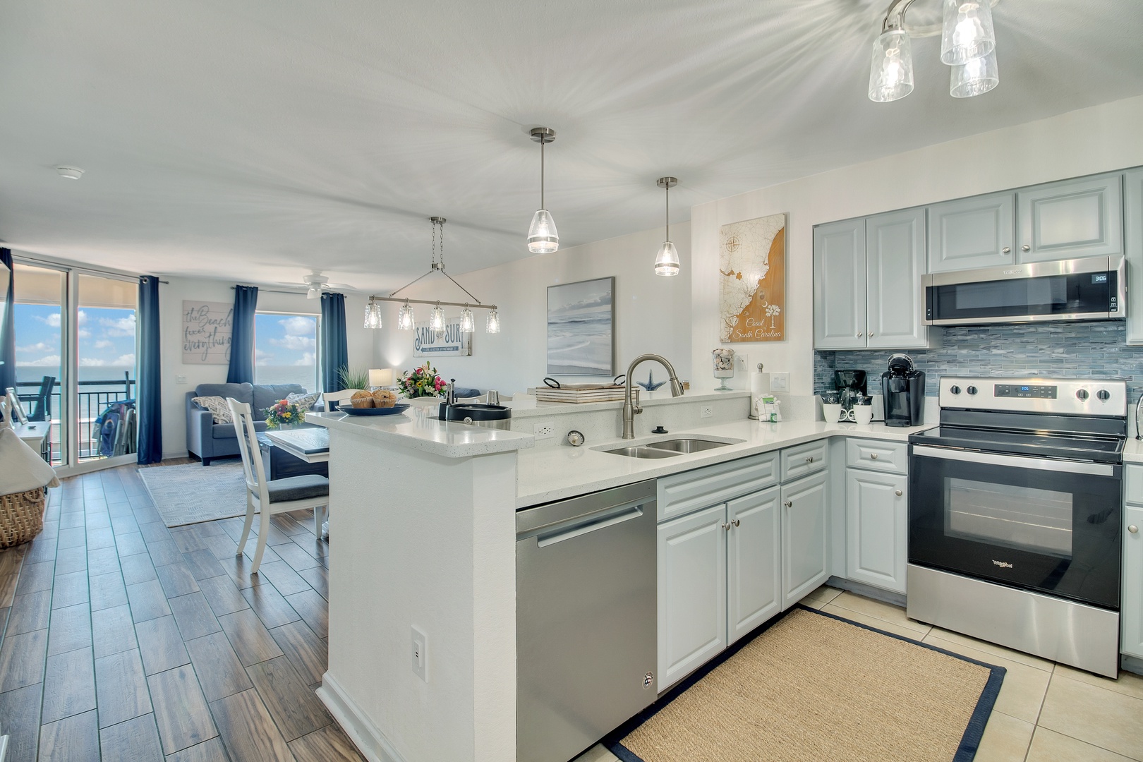 Your spacious oceanfront kitchen flows seamlessly into the living area, perfect for preparing meals while enjoying stunning views through floor-to-ceiling windows.
