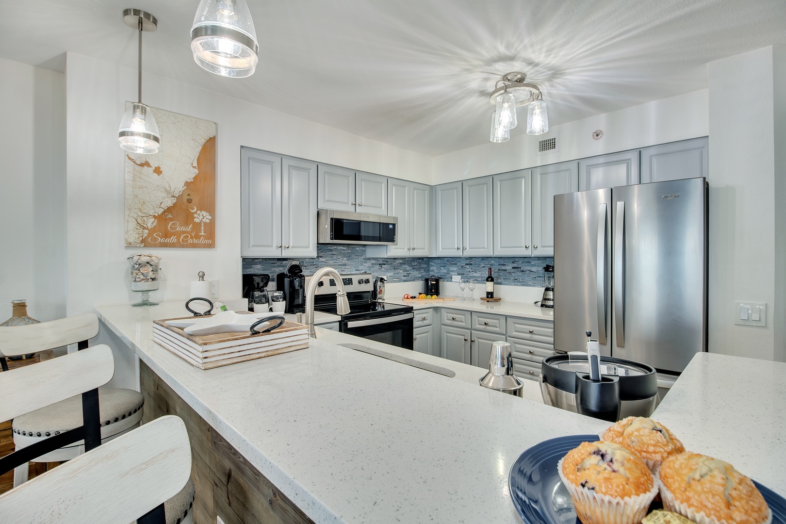 Your gourmet kitchen awaits with stunning quartz countertops, modern stainless appliances, and coastal-inspired touches perfect for creating memorable meals.