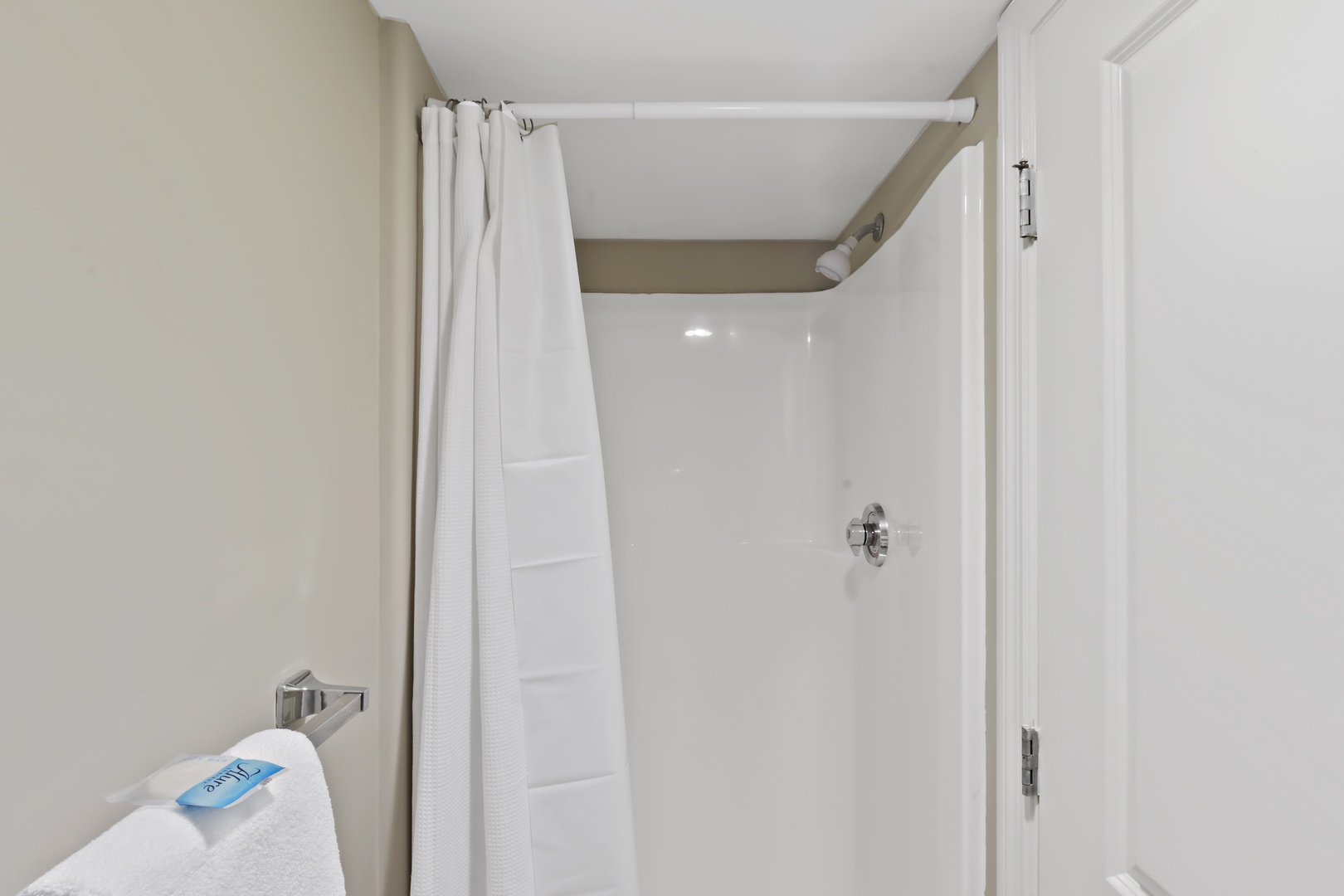 Step into your private bathroom featuring a spacious walk-in shower with crisp white finishes and fresh towels awaiting your arrival.