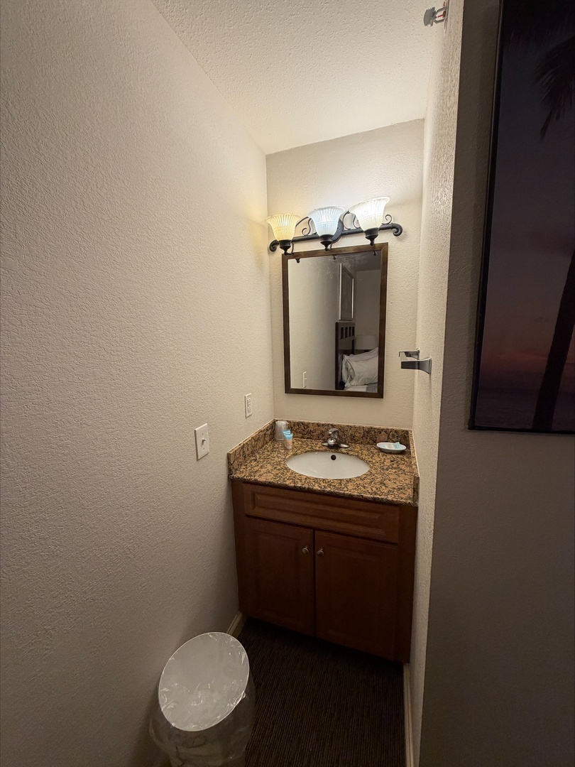 Your private bathroom offers a cozy vanity with warm lighting, granite countertop, and fresh towels — everything you need to refresh after a day of adventure.