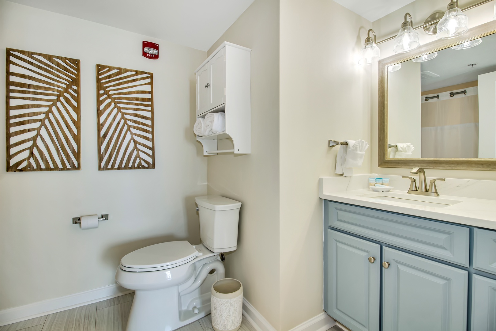 Refresh in your stylishly appointed bathroom featuring coastal-inspired blue vanity, modern fixtures, and thoughtful touches that make your stay comfortable.