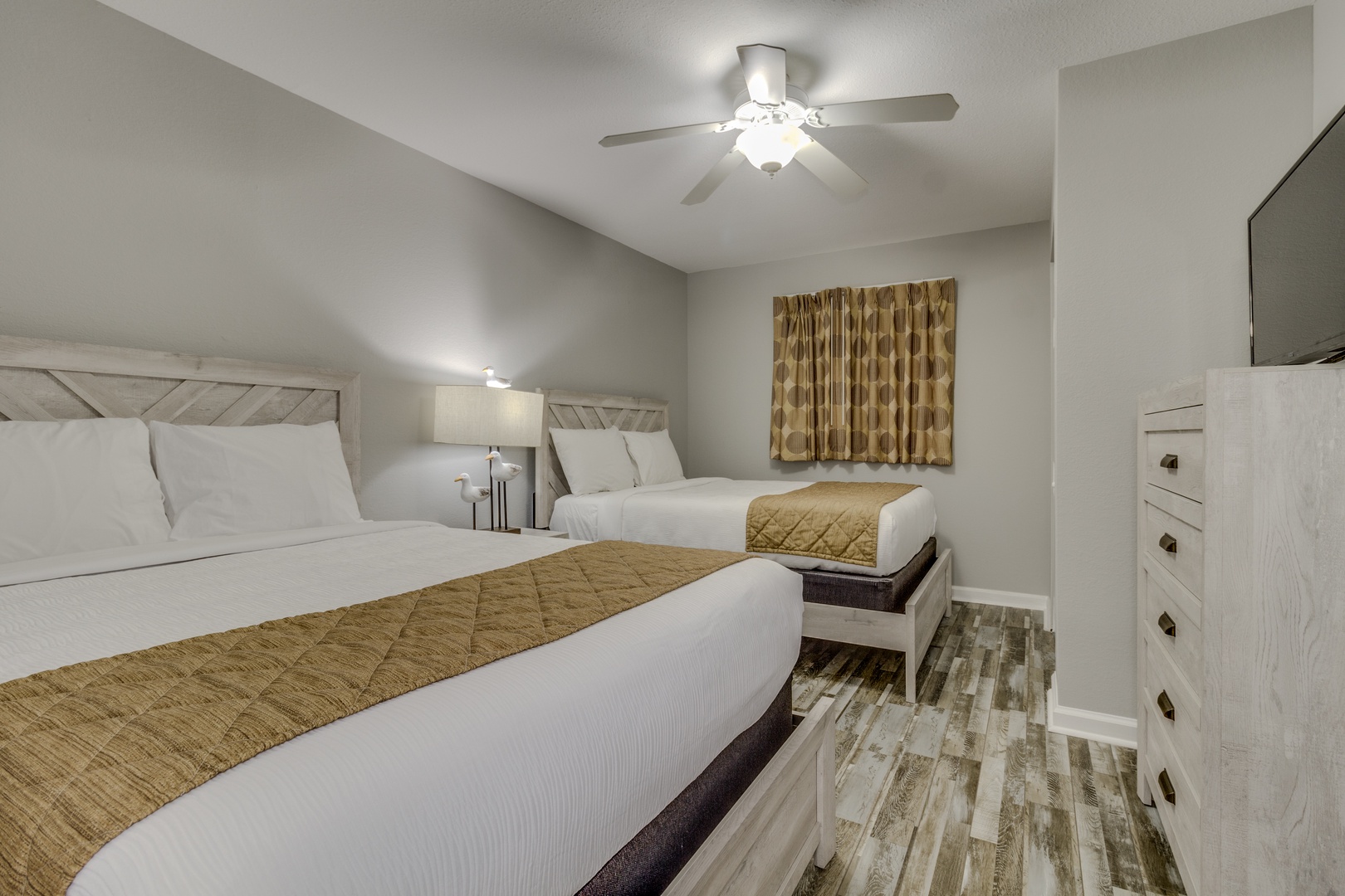 Rest peacefully in your serene bedroom with two comfortable beds, soft linens, and gentle ceiling fan creating the perfect sleep sanctuary.