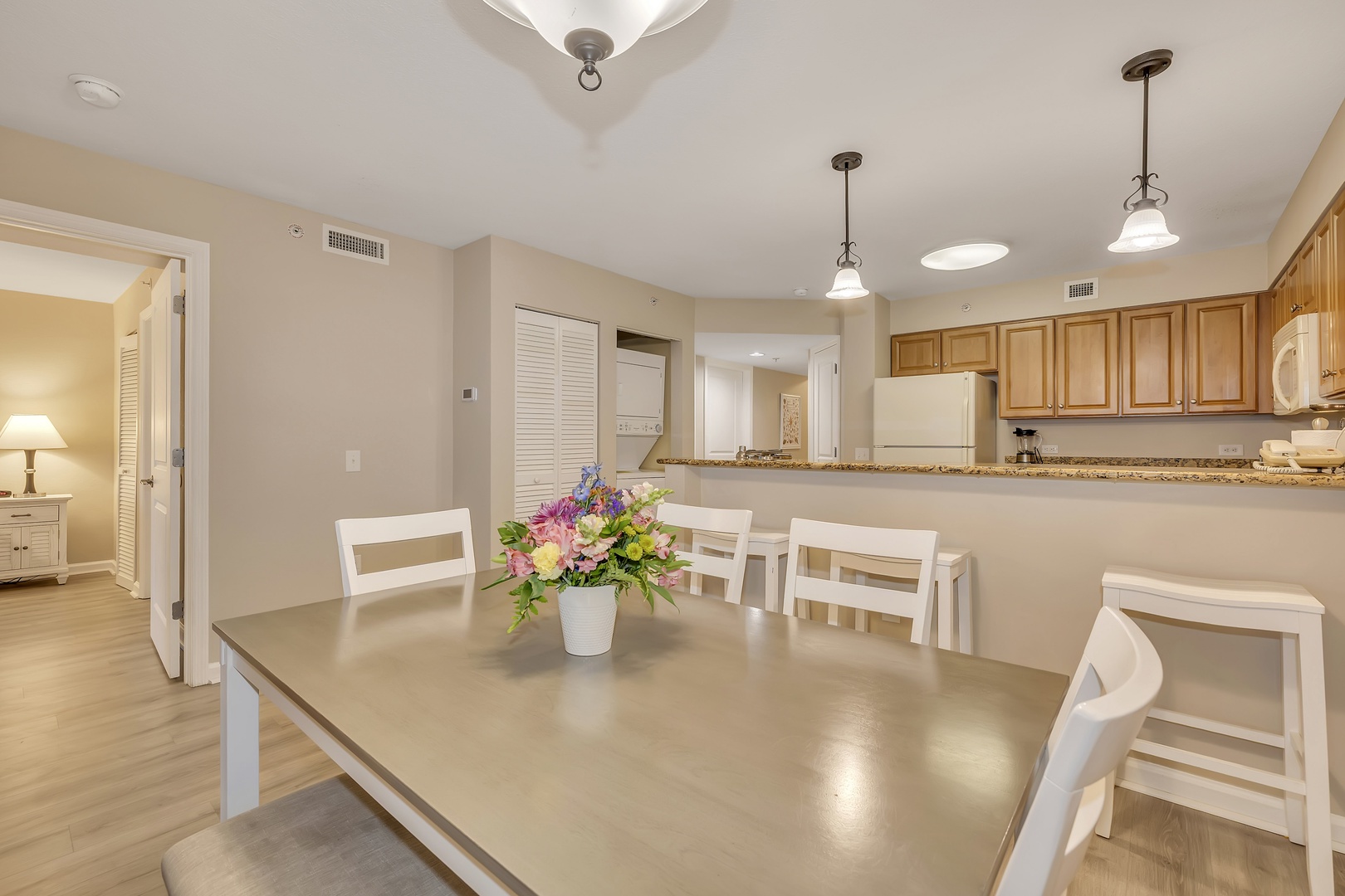 Gather around this spacious dining table for meals and memories. Natural light fills the open layout, flowing seamlessly into the full kitchen where you can prepare favorite dishes with ease.