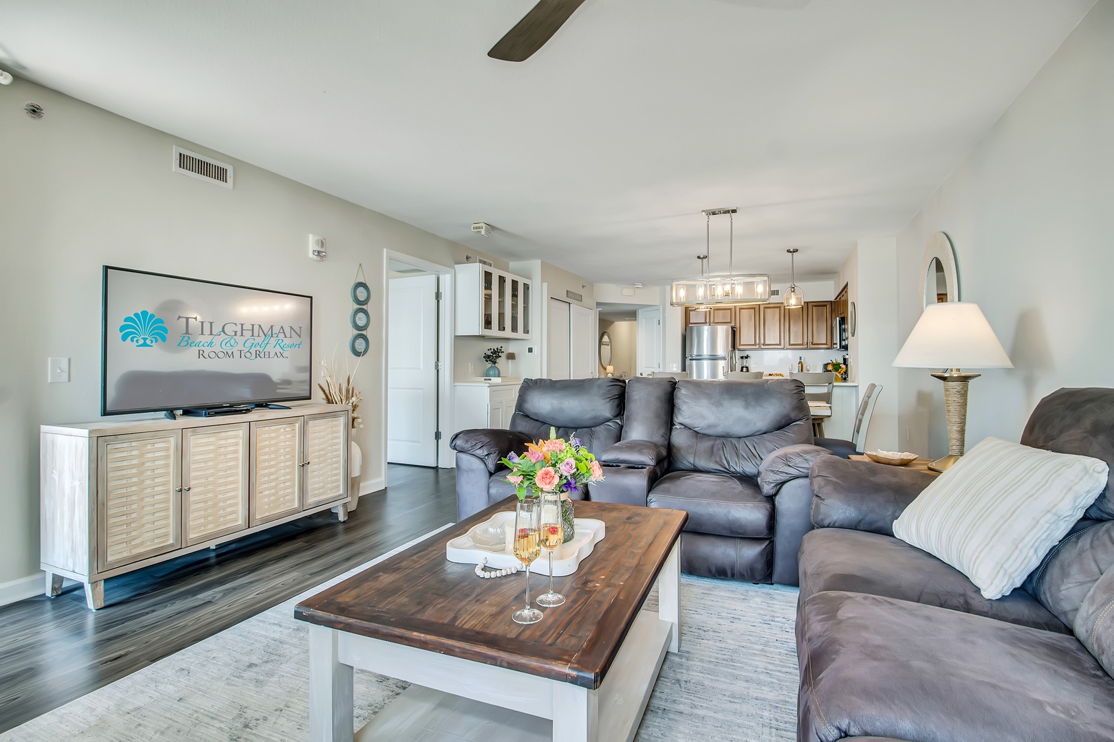 Sink into plush leather seating while enjoying your favorite shows in this beautifully appointed living space with modern kitchen and coastal touches.