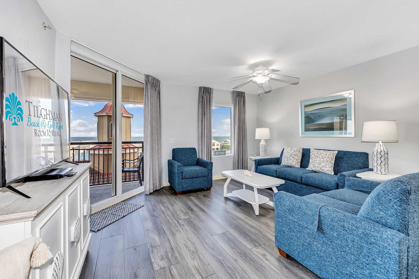 Step into your coastal retreat where comfortable blue seating and breezy coastal décor invite you to unwind. Sliding glass doors open to your private balcony, revealing ocean glimpses and endless sky.