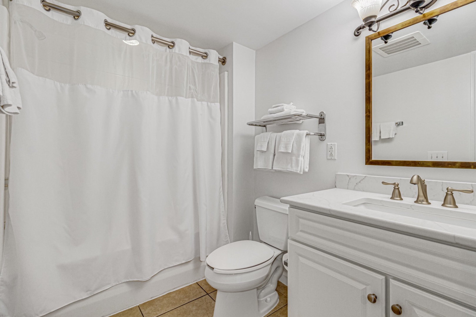 Step into your clean, well-appointed bathroom featuring fresh towels and modern fixtures for your comfort.