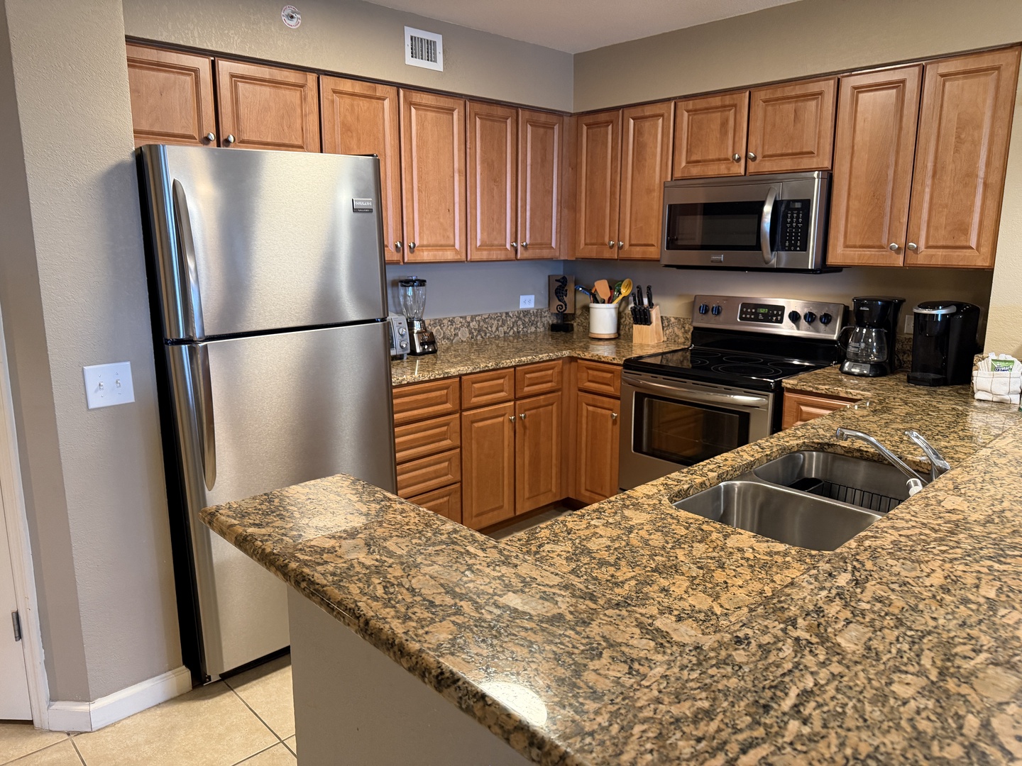 Step into your fully equipped kitchen with granite countertops, stainless steel appliances, and warm wood cabinetry—perfect for preparing memorable meals.