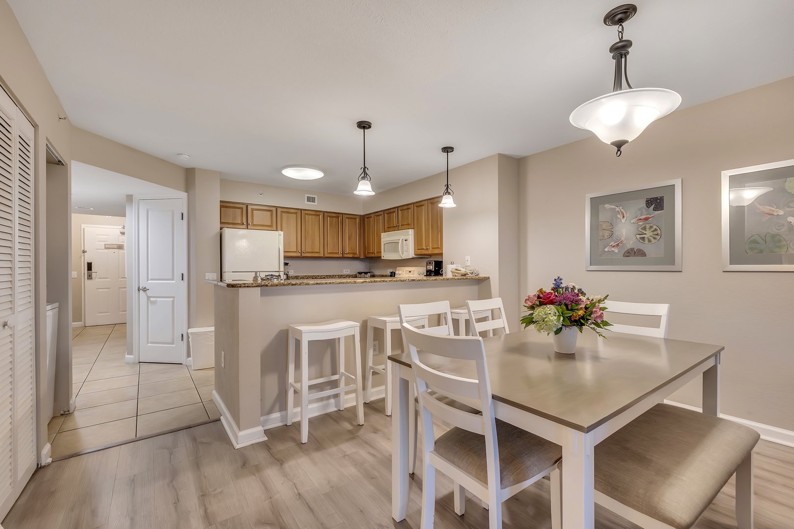 Gather around the spacious dining table for memorable meals with family and friends. The open kitchen design invites conversation as you enjoy your time together in this bright, welcoming space.