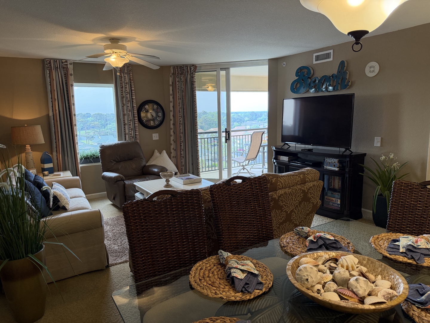 Unwind in your coastal-themed living room with wicker chairs and beach décor, while enjoying panoramic views from your private balcony.