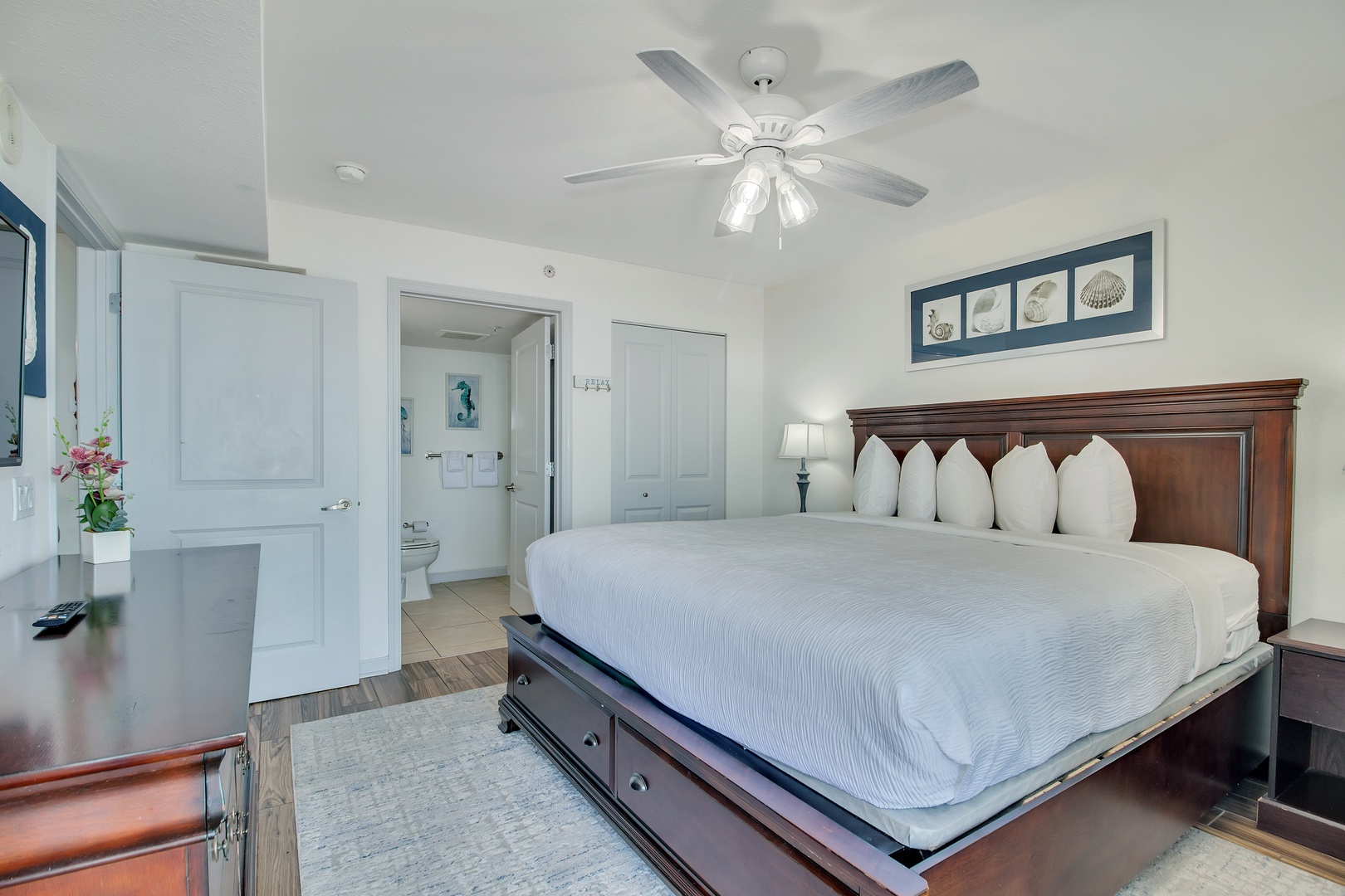 Unwind in your peaceful bedroom featuring a plush king bed, elegant furnishings, and coastal artwork that creates the perfect retreat.