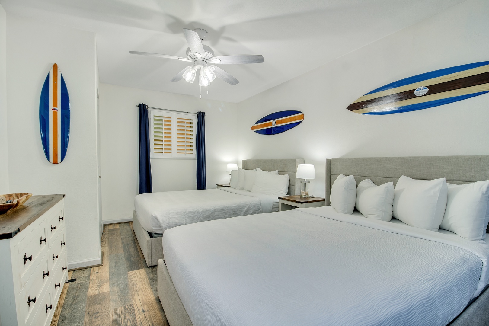 Drift off in your surf-inspired twin bedroom with crisp white linens and coastal charm overhead.