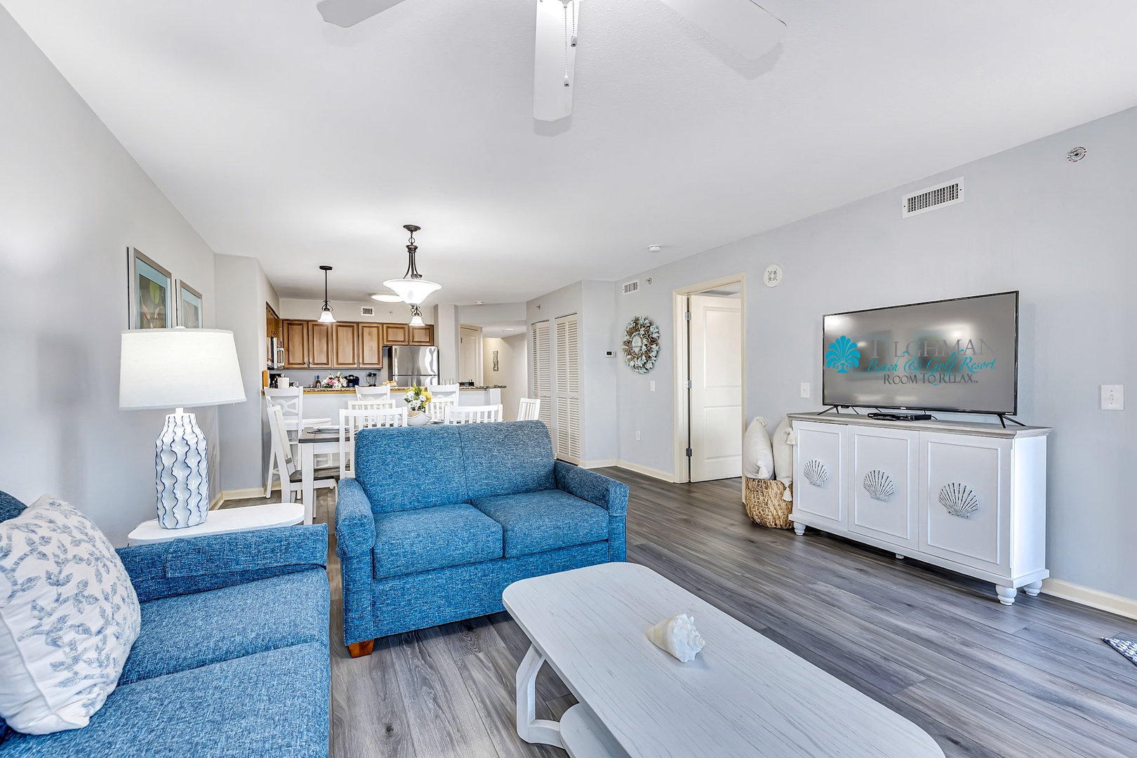 Step into your airy open-concept retreat where soft blues meet coastal charm. Vaulted ceilings and warm wood floors welcome you, while the full kitchen and cozy seating invite easy mornings and relaxed evenings.