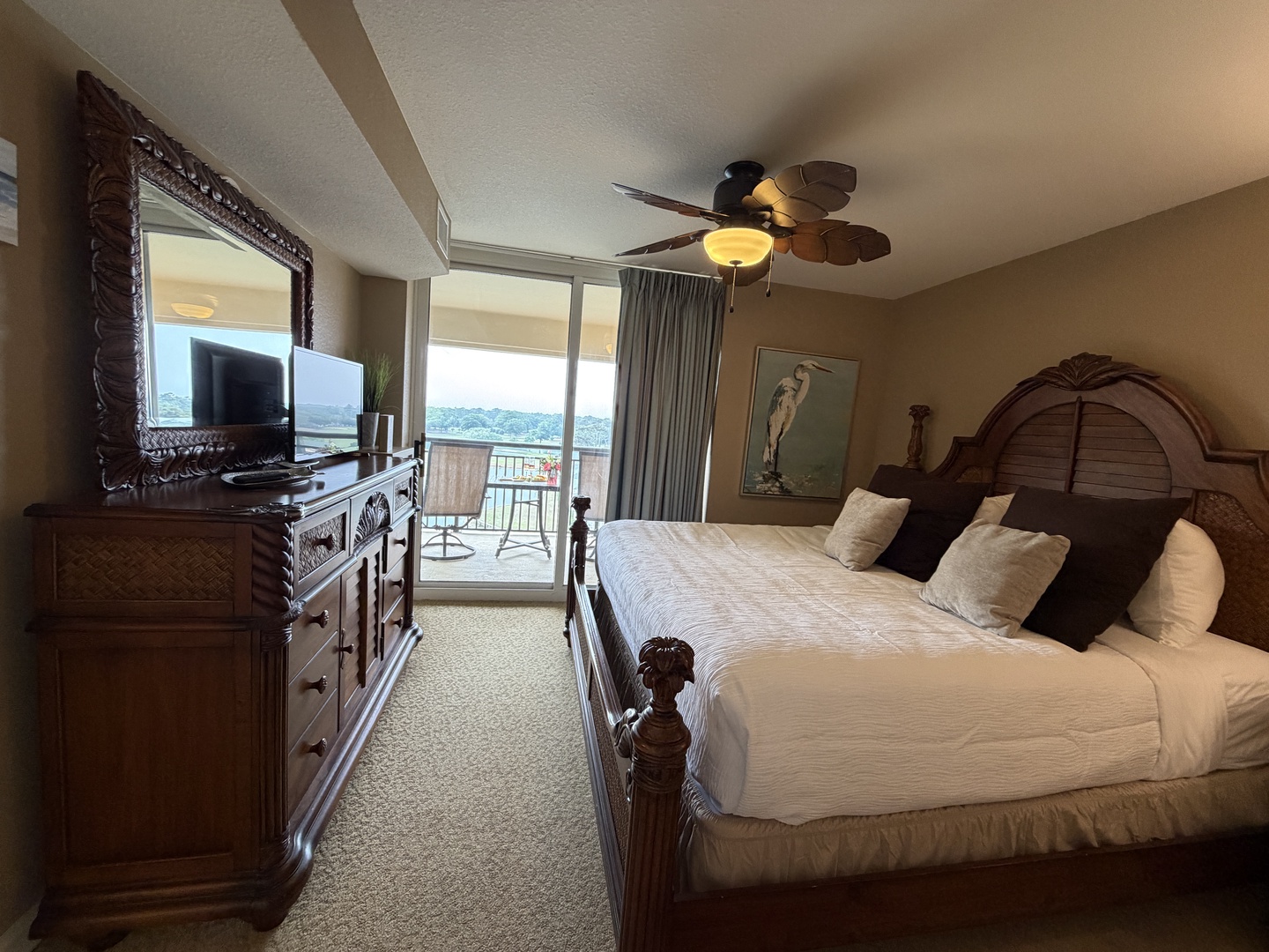 Sink into your plush king bed and unwind as natural light streams through the balcony doors, revealing stunning views beyond your private retreat.
