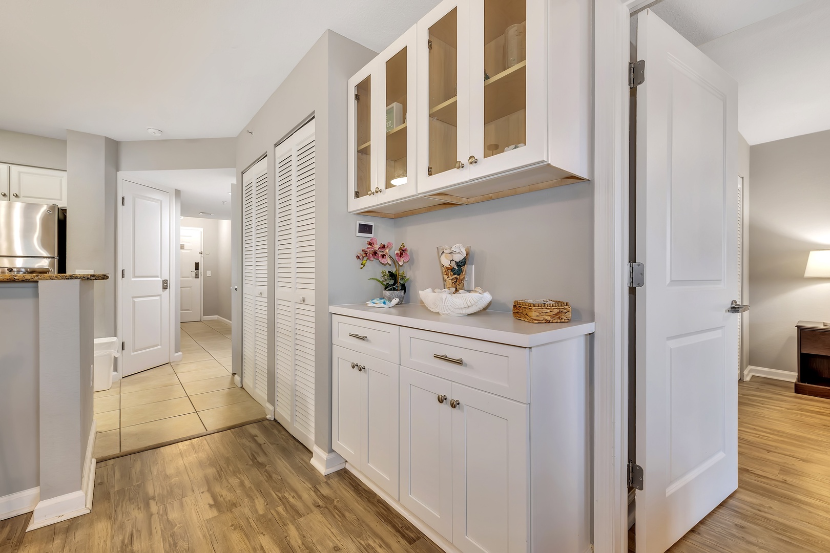 Your bright kitchen flows seamlessly into a well-organized hallway, complete with custom built-in cabinets for all your storage needs and stylish louvered closet doors for extra convenience.