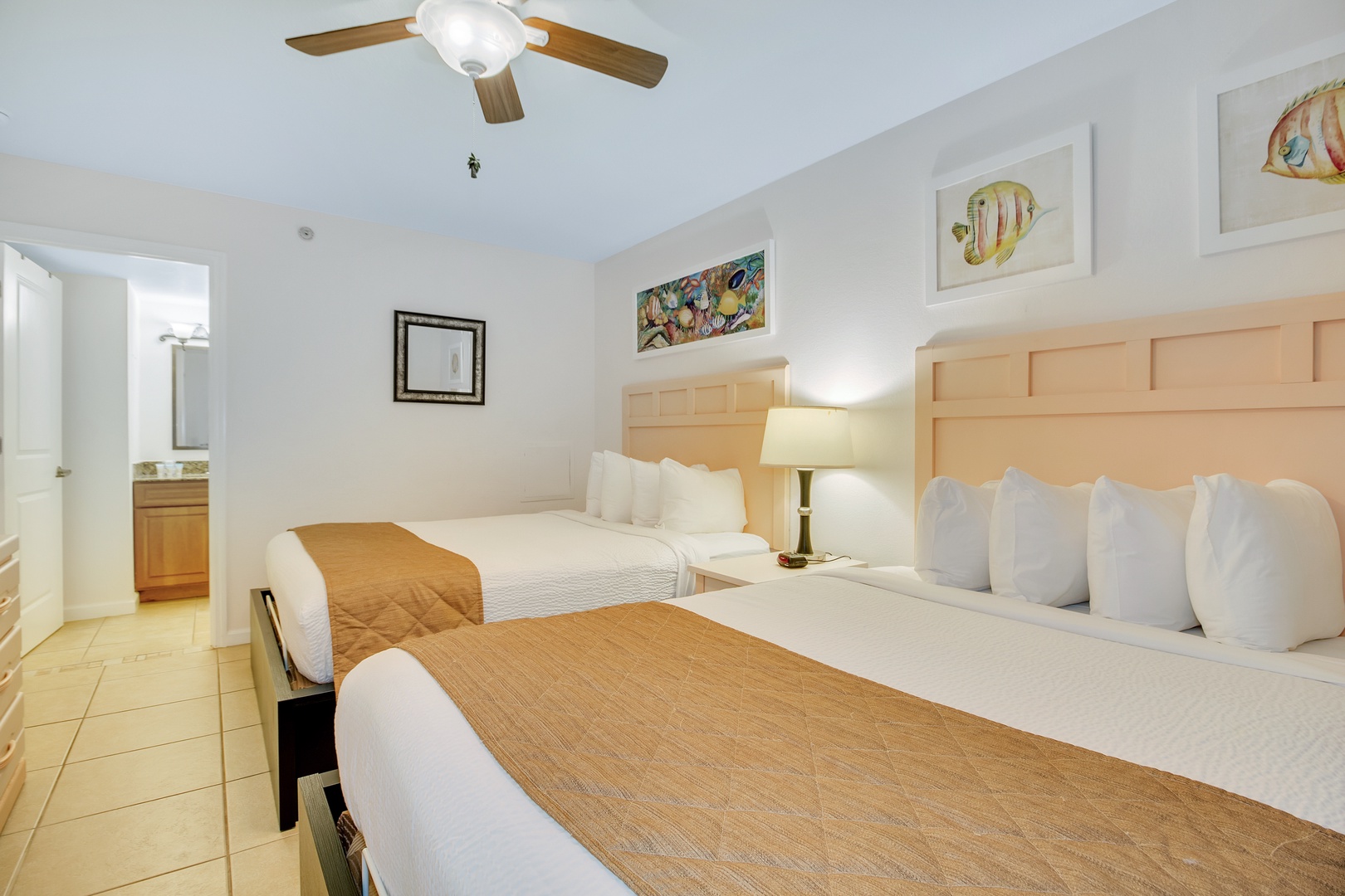 Relax in your bright, coastal-themed bedroom with two comfortable beds and charming tropical fish artwork welcoming you home.