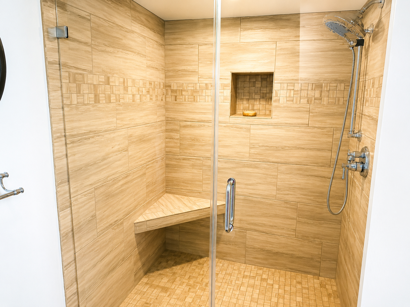 Unwind in your private spa-like shower with a built-in teak bench, rainfall showerhead, and elegant mosaic tile accents—pure relaxation awaits.