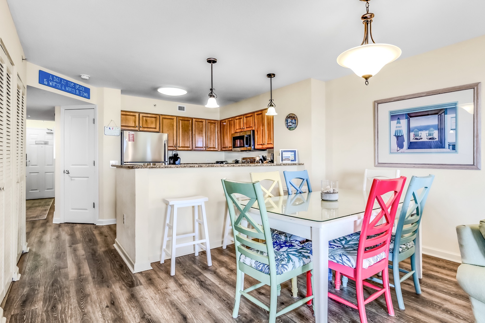 Your bright coastal dining space features cheerful chairs and a breakfast bar perfect for morning coffee.