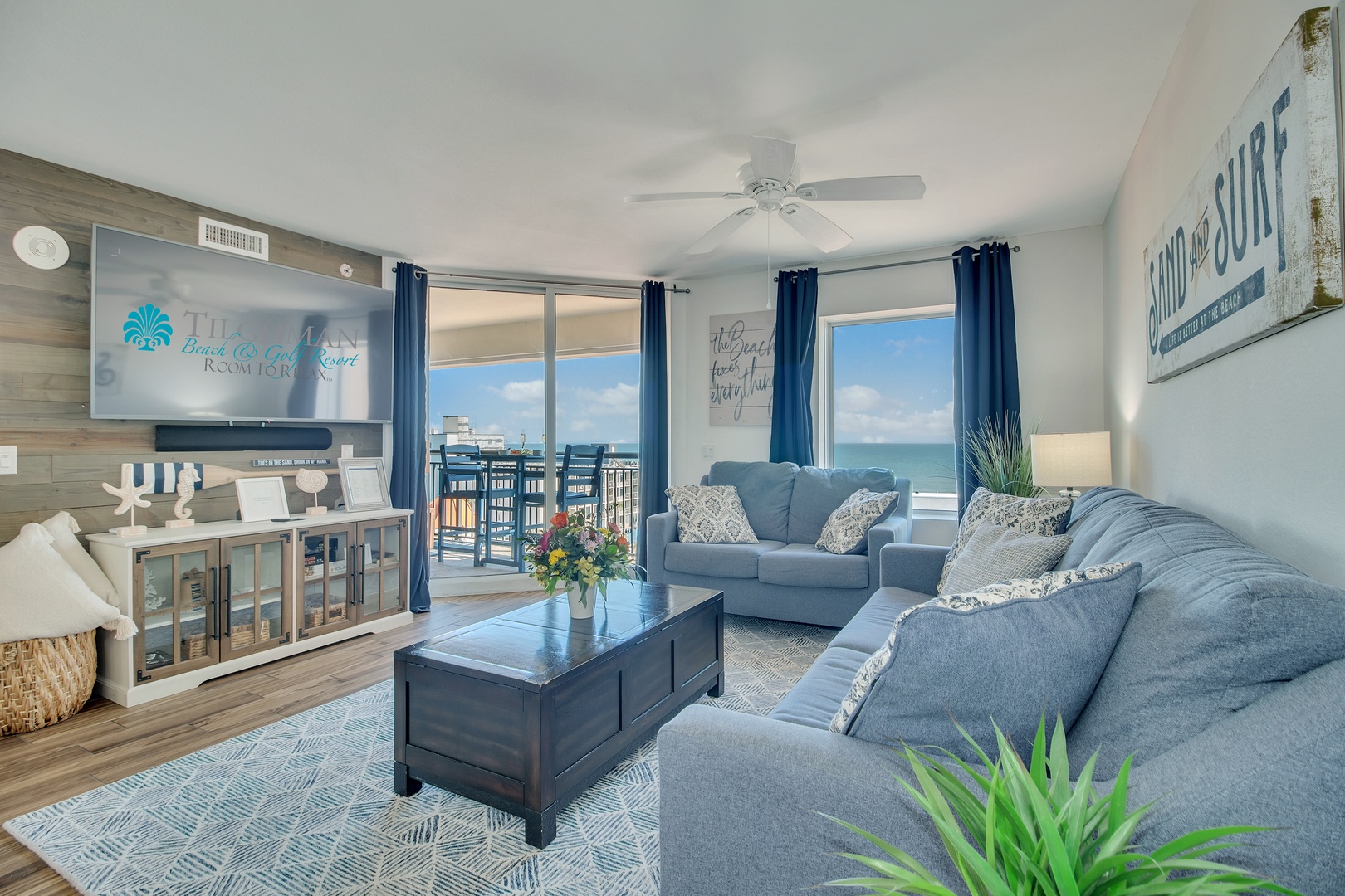 Sink into plush blue sofas while ocean views fill your windows, creating the perfect seaside retreat for relaxation.