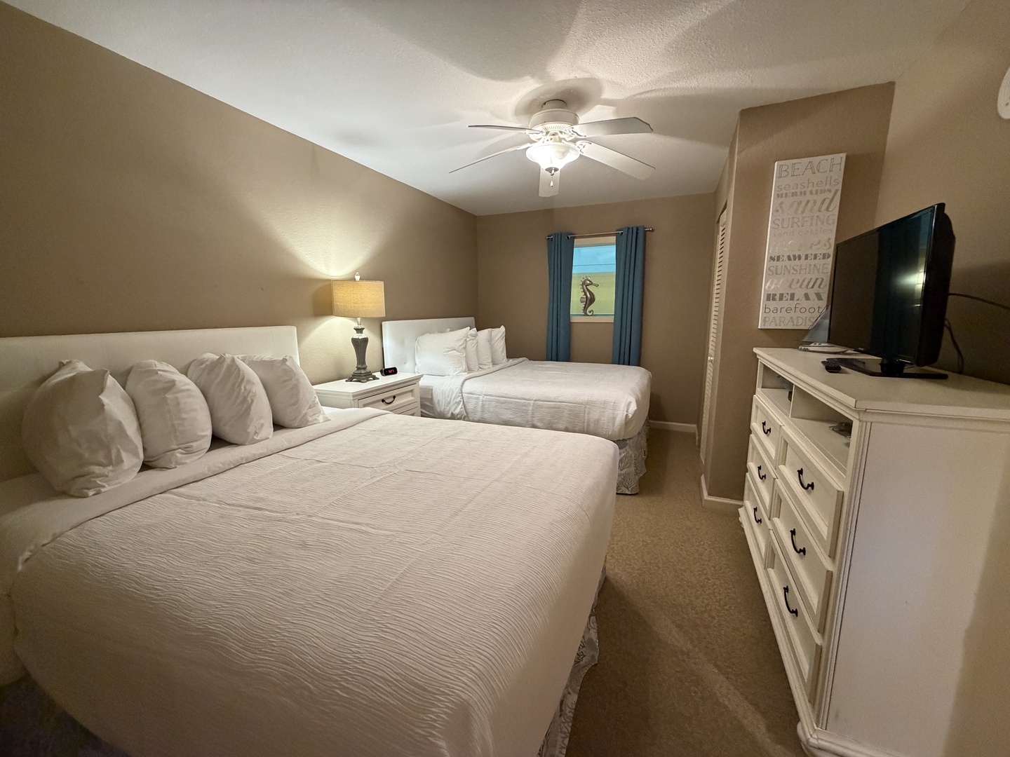 Sink into crisp white linens in your peaceful twin bedroom, complete with entertainment and gentle ceiling fan breezes for perfect comfort.