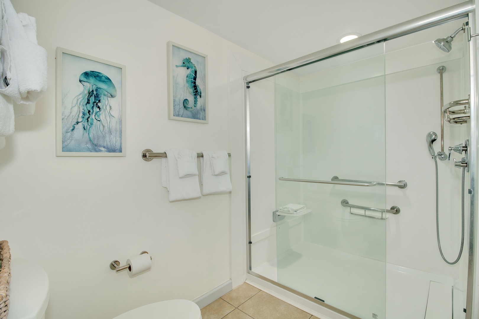 Refresh in your spacious glass shower with coastal artwork and plush towels at your fingertips.
