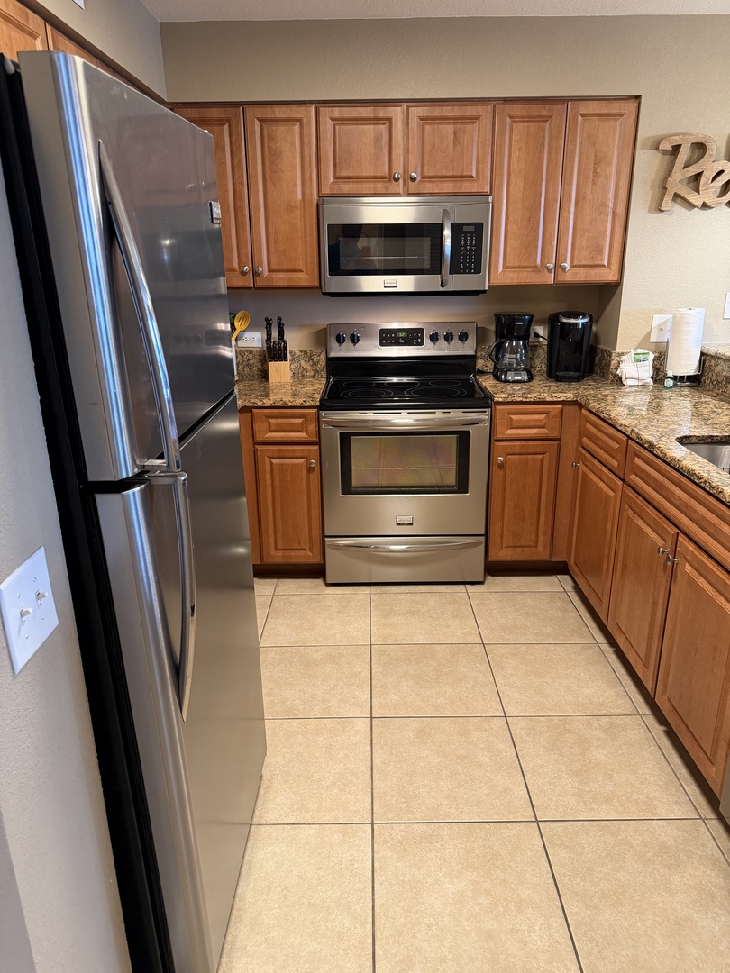 Your fully equipped kitchen awaits with sleek stainless appliances, warm wood cabinets, and granite counters for memorable meal prep.