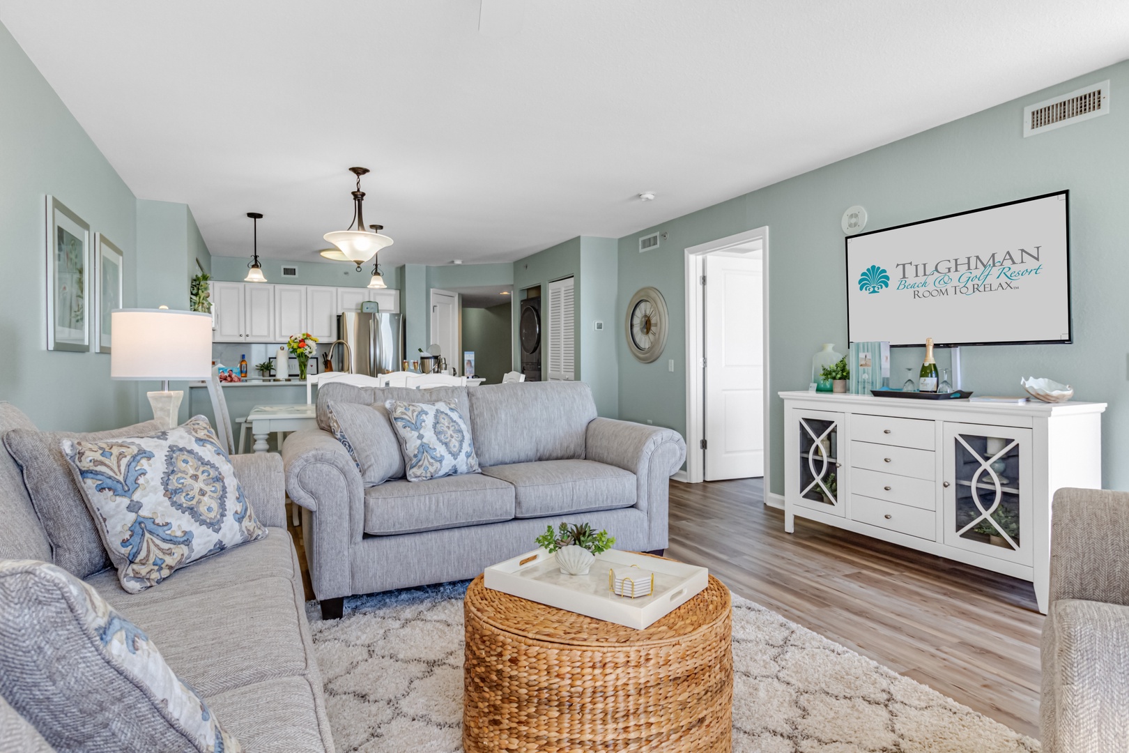 Sink into plush sofas in your bright open-plan living space, where coastal blues and whites create a calming beach retreat.